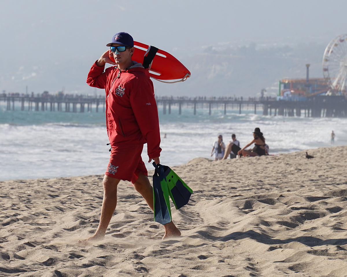 Kool life guard, scrolling the beach sporting Noz-up  odorless sunscreen. 